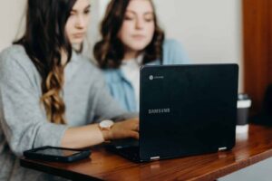 Woman using Chromebook with phone